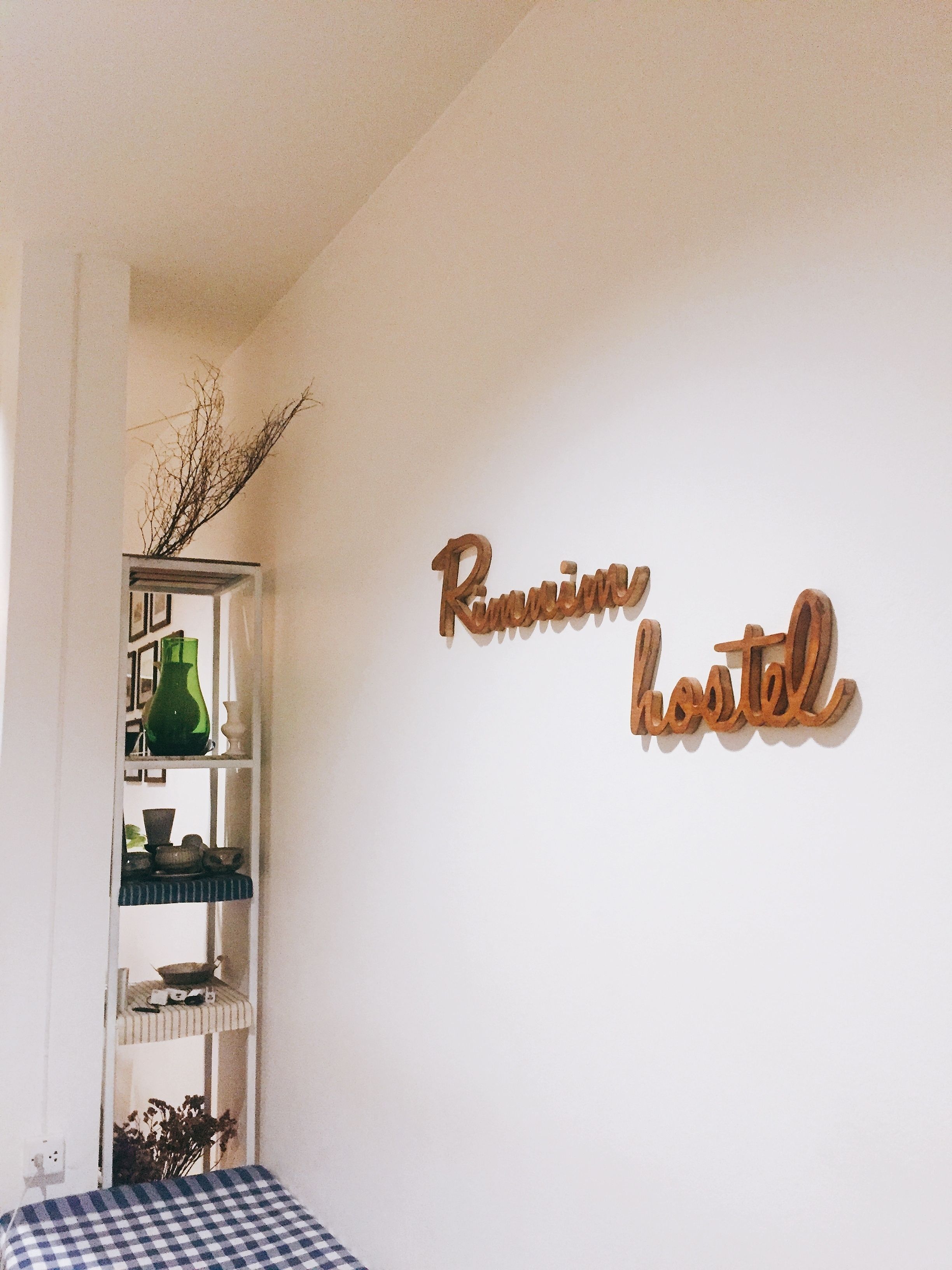 A room with a wall-mounted sign reading "Rimini hostel".