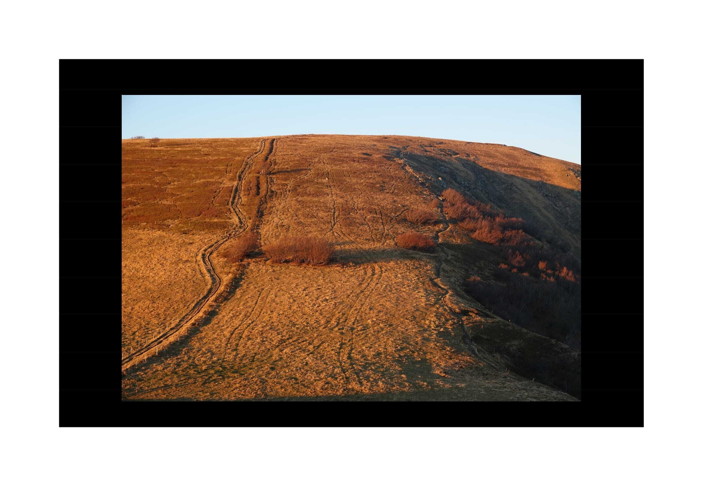 A panoramic view of a hilly landscape with a clear sky.