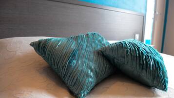 Una cama con una colcha estampada y dos almohadas de diseño texturizado.