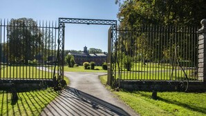 A gated entrance to a building with a clear pathway leading to it. - Logis hôtel du château de la motte (Liessies)