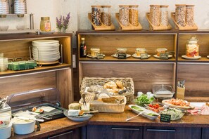 A buffet setup with various food items and condiments.