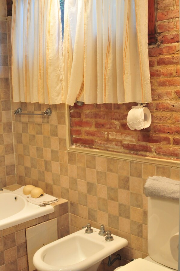 A bathroom with a checkered tile wall, a bathtub, a sink, and a toilet.