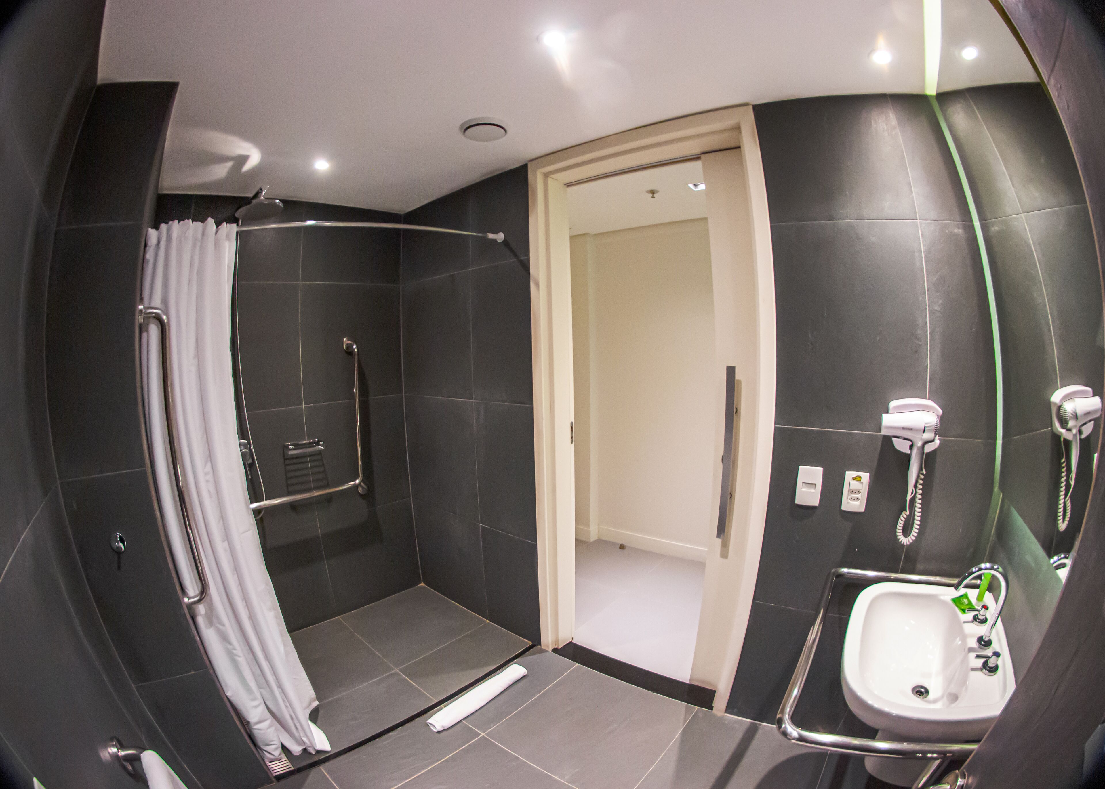 Un baño moderno con cabina de ducha, inodoro y lavabo.
