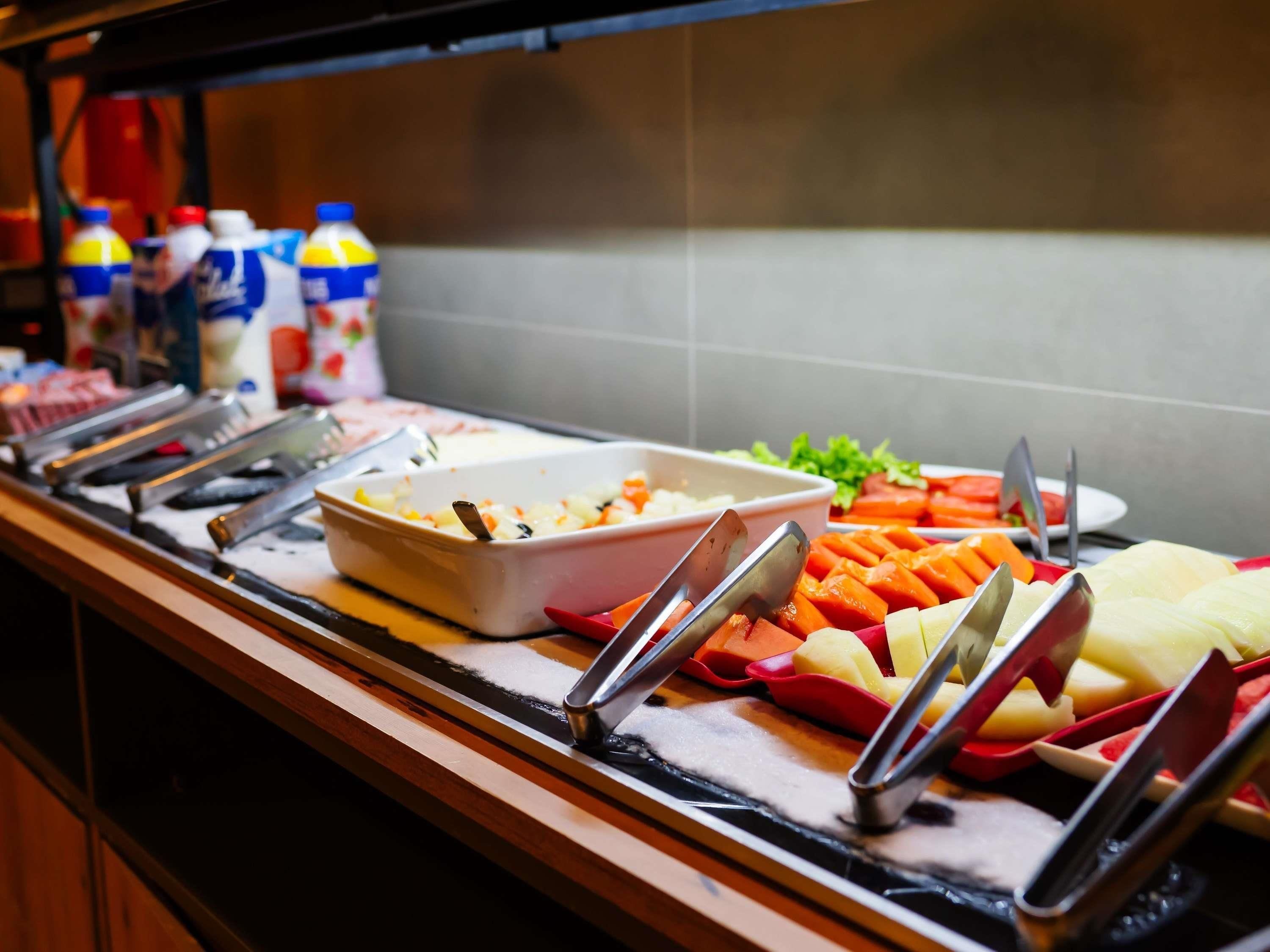 Una mesa de buffet con diferentes alimentos y utensilios.
