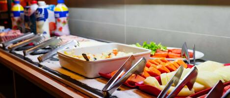 Una mesa de buffet con diferentes alimentos y utensilios.