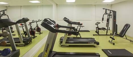 A gym with treadmills, weight machines, and free weights.