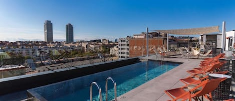 Ein Pool auf dem Dach mit Blick auf die Stadt, darunter Hochhäuser.