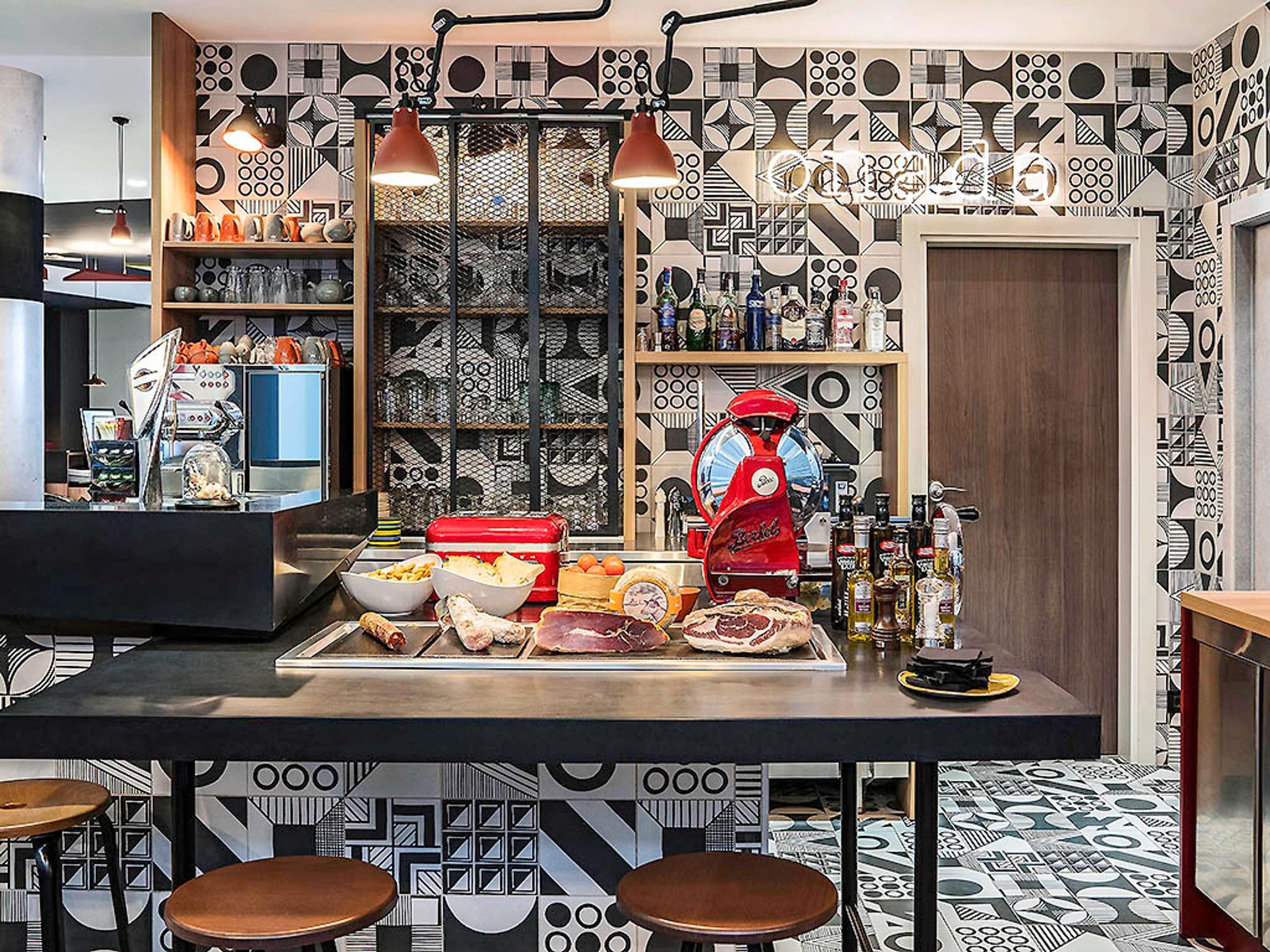 Una cocina con una isla central, taburetes de bar y un papel tapiz estampado.
