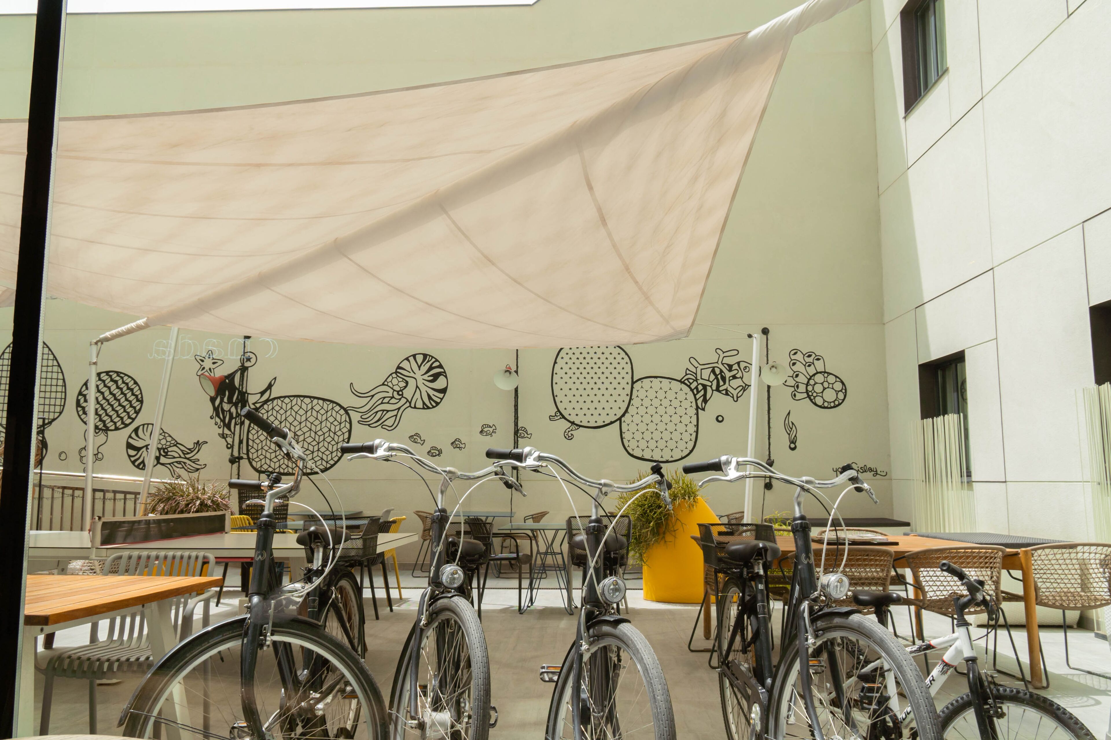 Un espacio de estar al aire libre cubierto con bicicletas estacionadas bajo una marquesina.