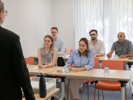 A conference room with a long table, chairs, and a whiteboard.
