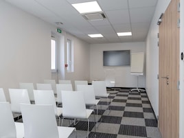 Un salón de conferencias con sillas blancas, una pantalla grande y piso a cuadros.