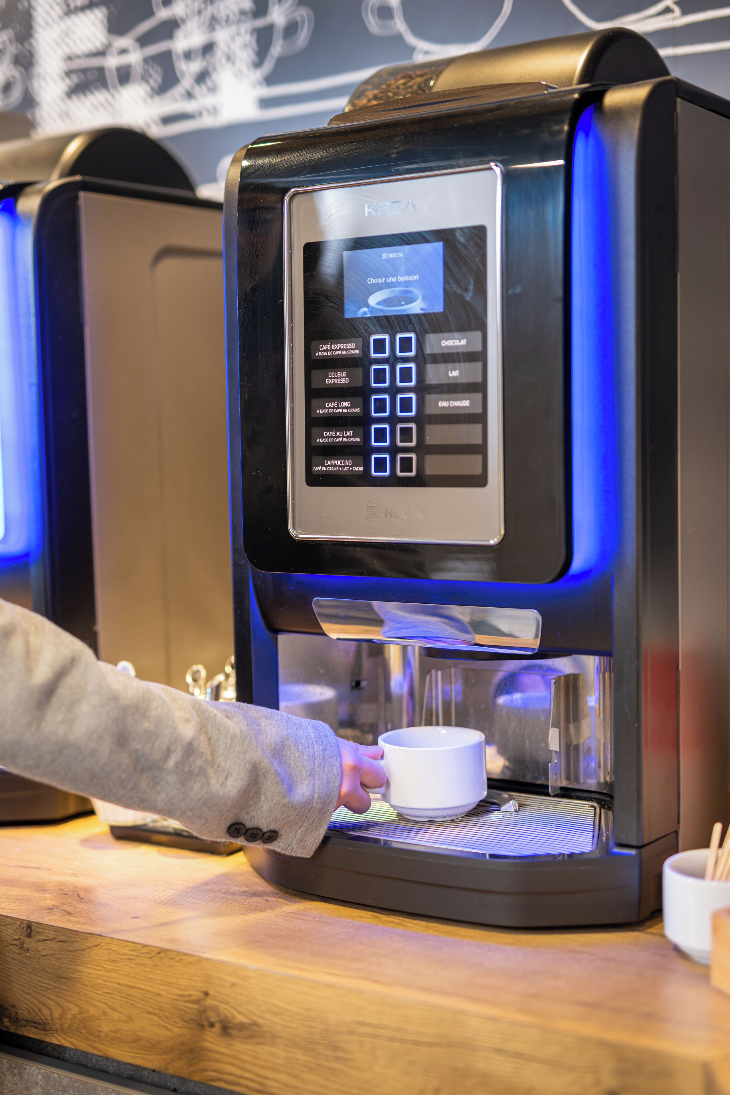 A coffee machine with a digital interface and a cup placed underneath.