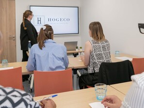 A conference room with a presentation screen displaying 'HOGEOCO SALLES DE SEMINAIRE'. - ibis budget Lyon Caluire Cite Internationale (Caluire-et-Cuire)