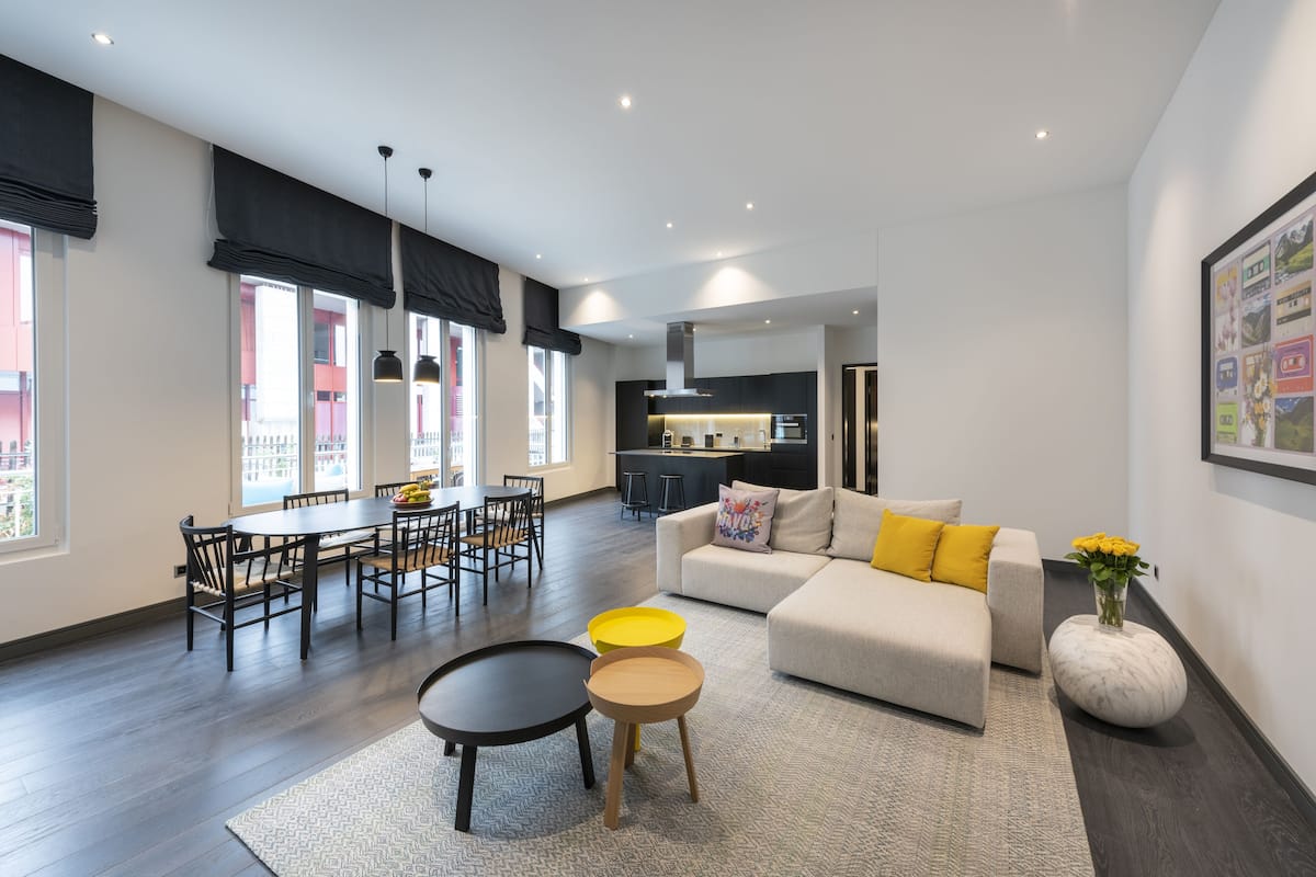 A modern living room with a sofa, coffee table, and dining area.