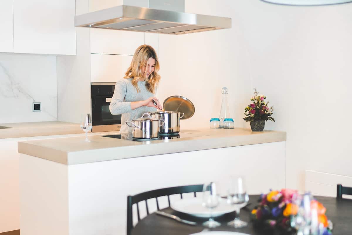 A modern kitchen with a central island, stainless steel appliances, and a dining area with a table set for two.