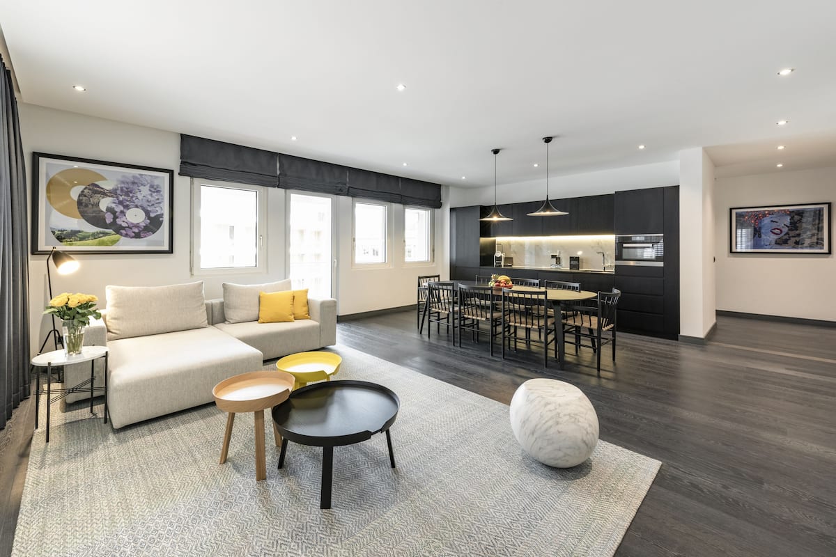 A modern living room with a sofa, coffee table, and dining area.