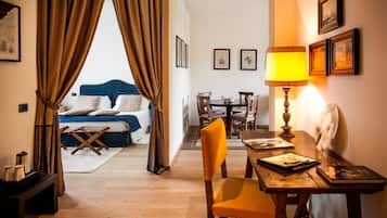 Une chambre d’hôtel avec un lit, une table à manger, une lampe et une chaise.