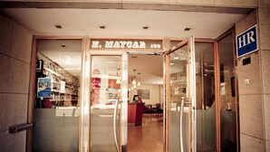 Entrada d'un hotel amb porta de vidre, una recepció i un senyal que indica 'Recursos Humans'.