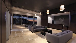Un vestíbul d'hotel modern amb una àrea d'estar amplia, una recepció i una finestra gran que ofereix vistes a la ciutat.