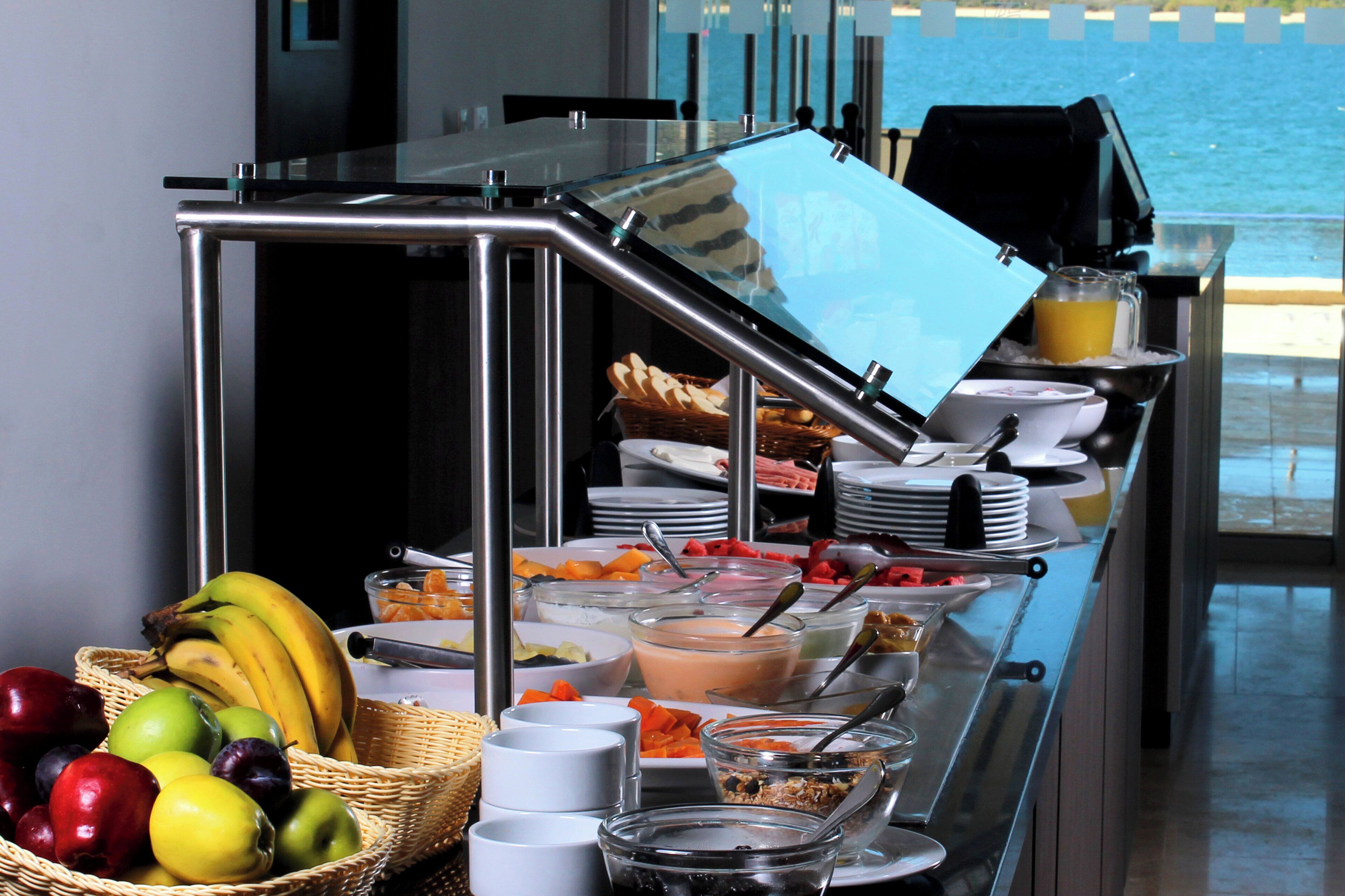 Uma mesa de buffet com diversos alimentos e utensílios.