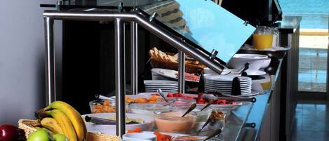 A buffet setup with various food items and utensils.