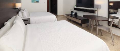 A hotel room with two beds, a TV, a desk, and a chair.