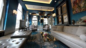 A modern hotel lobby with a blue color scheme, leather seating, and contemporary decor. - Elyton Hotel, Autograph Collection by Marriott (Birmingham)