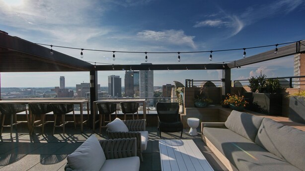An outdoor patio with seating, a table, and string lights. - Elyton Hotel, Autograph Collection by Marriott (Birmingham)
