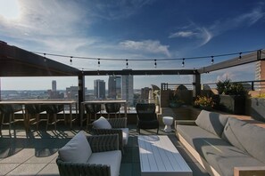 An outdoor patio with seating, a table, and string lights. - Elyton Hotel, Autograph Collection by Marriott (Birmingham)