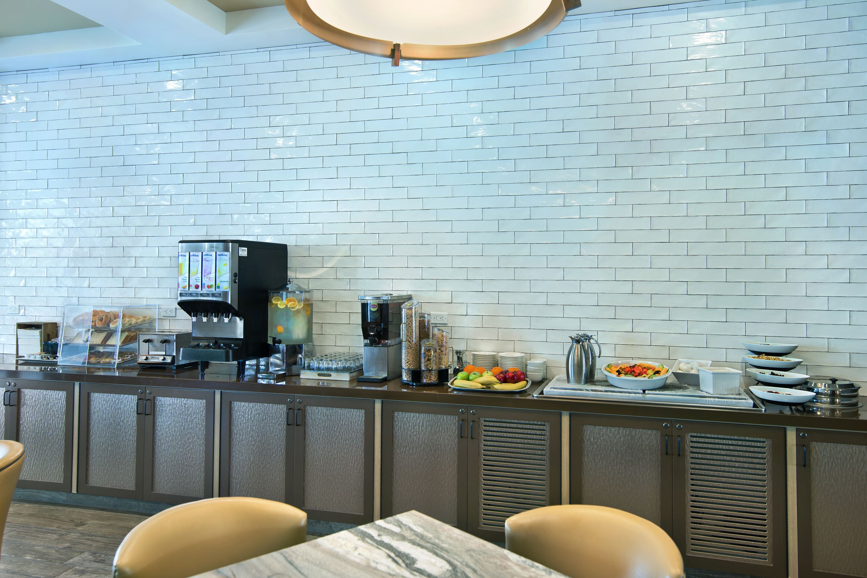 A breakfast bar with a coffee machine, a fruit bowl, and a variety of breakfast items.