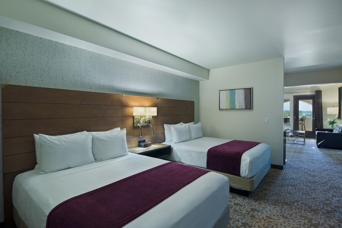 Ein Hotelzimmer mit zwei Betten, einem Nachttisch, einer Lampe und einem Bild an der Wand.