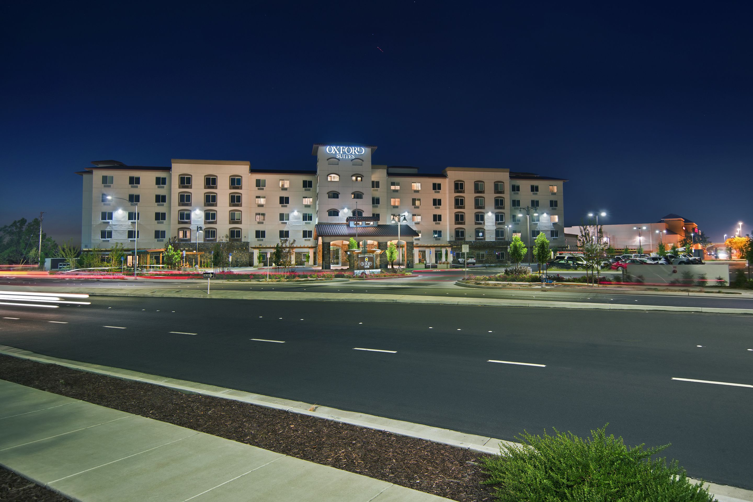 A hotel with a prominent sign, multiple floors, and a well-lit entrance.