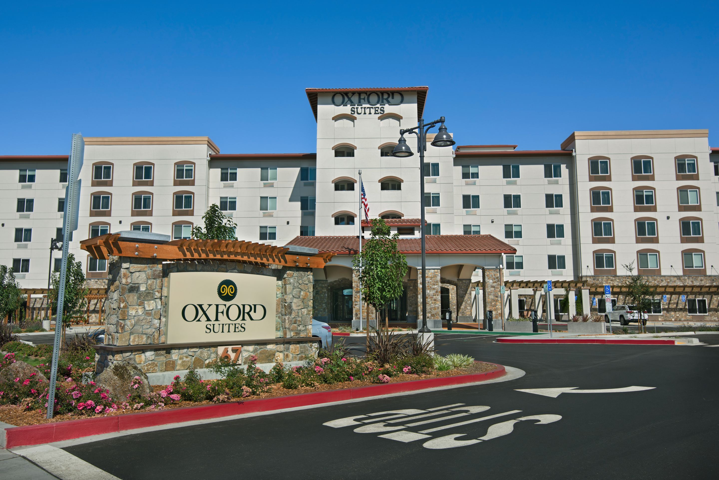 A hotel with a stone entrance, multiple floors, and a clear blue sky.