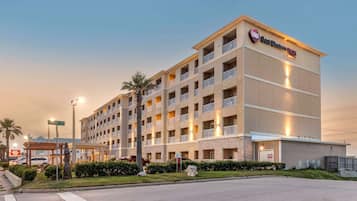Experience the charm of this hotel, featuring a symmetrical facade with balconies on each floor and a covered entrance.