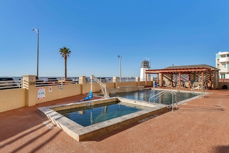 Una piscina al aire libre, sillones reclinables de piscina. Best Western Plus Galveston Suites