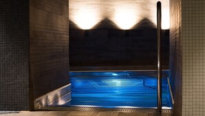 A modern indoor swimming pool with a wooden floor and tiled walls. - Lydia Hotel (Tartu)