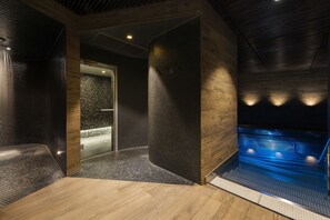 A modern spa area with a wooden floor, a heated floor section, and a glass door leading to an outdoor area. - Lydia Hotel (Tartu)