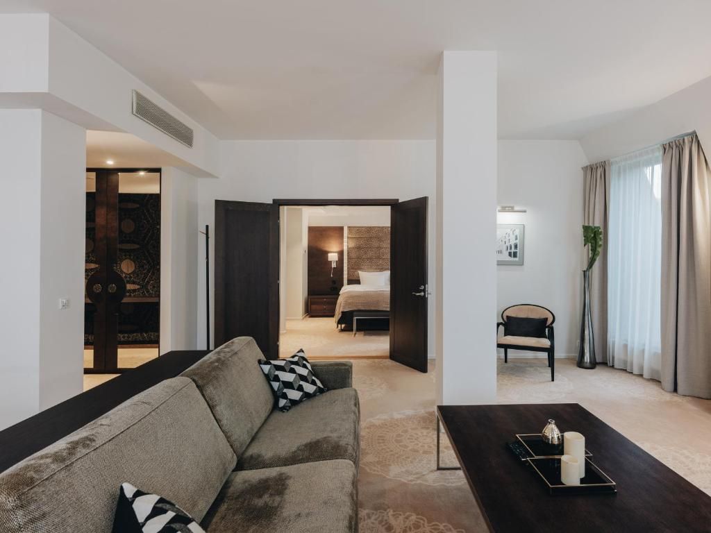 Una sala moderna con sofá, una mesa de centro y vistas hacia un dormitorio.