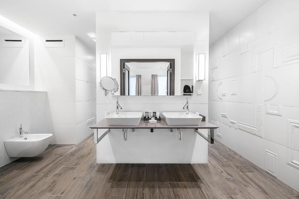 Un baño moderno con dos lavamanos, un mueble de tocador y un bidé.