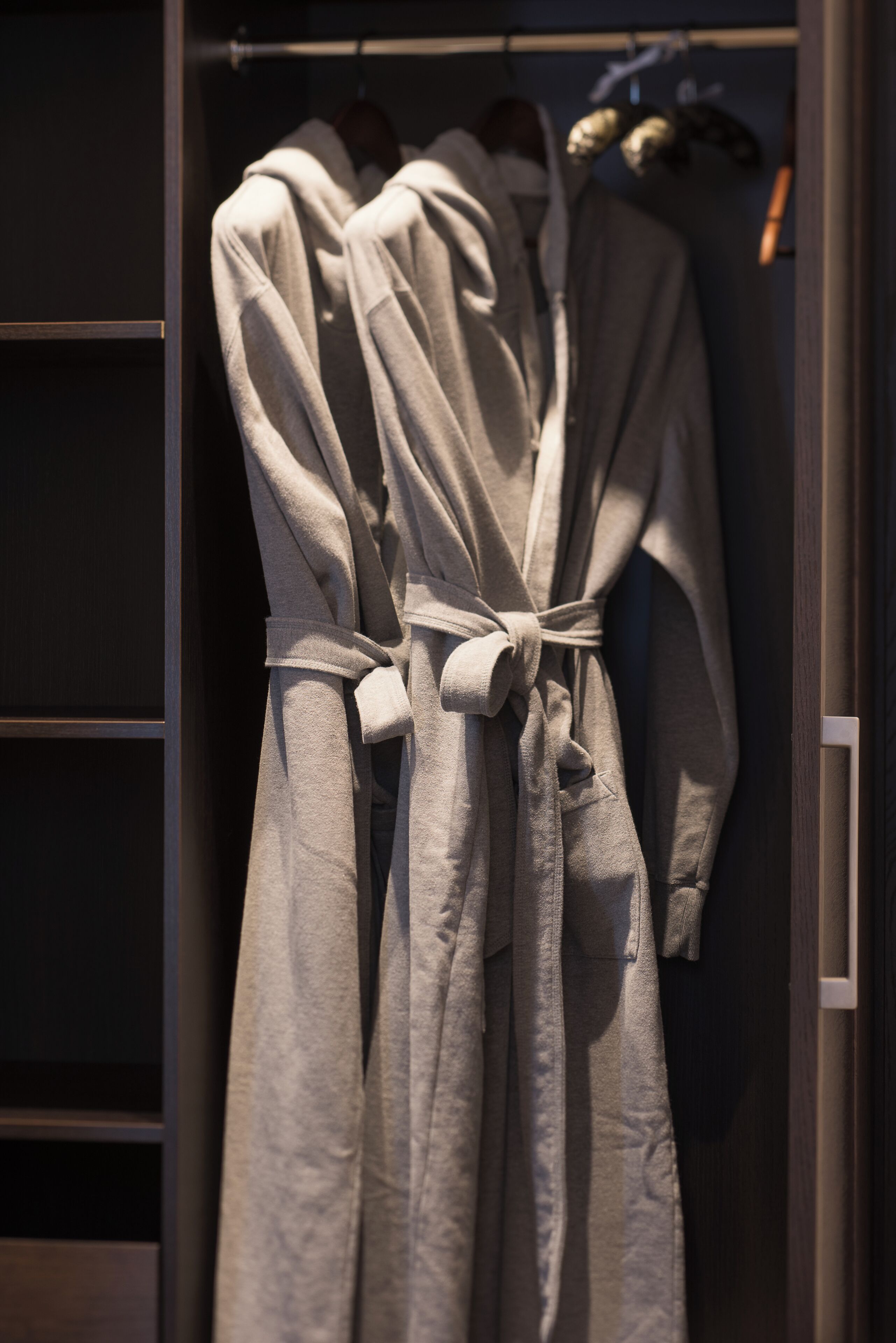 Ein Kleiderschrank mit mehreren Kleidungsstücken an einem Gestell.