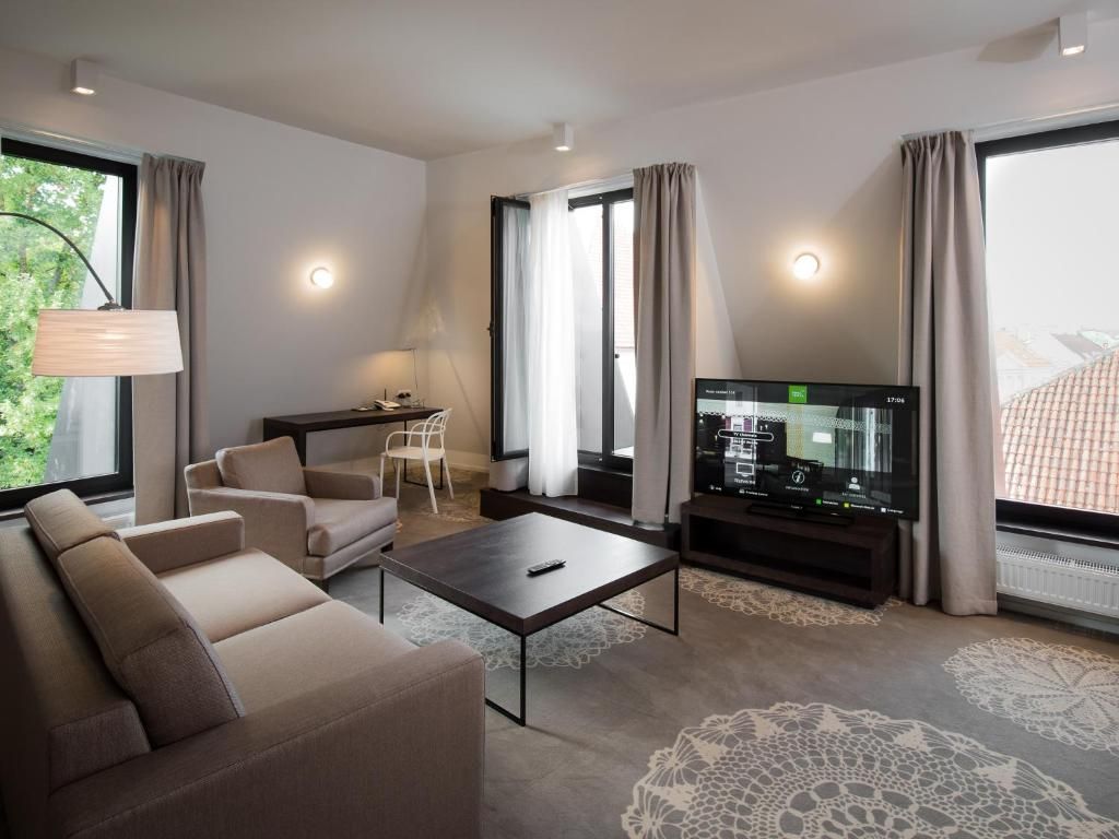 Uma sala de estar moderna com sofá, mesa de centro, televisão e poltrona.