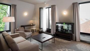 Uma sala de estar moderna com sofá, mesa de centro, televisão e poltrona.