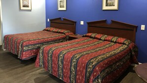 A hotel room with two beds, each with a patterned bedspread. - Fullerton Lodge (Fullerton)