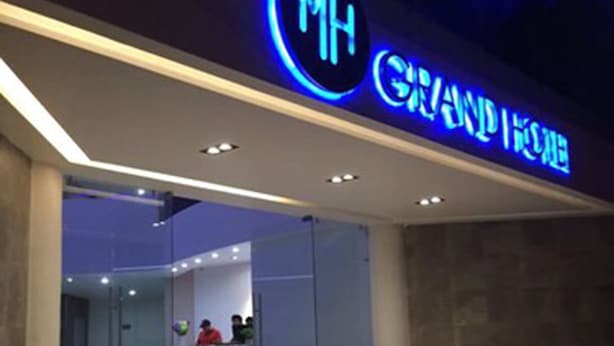 A hotel entrance with a neon sign reading "MH GRAND HOUSE". - MH Grand Hotel (Ometepec)