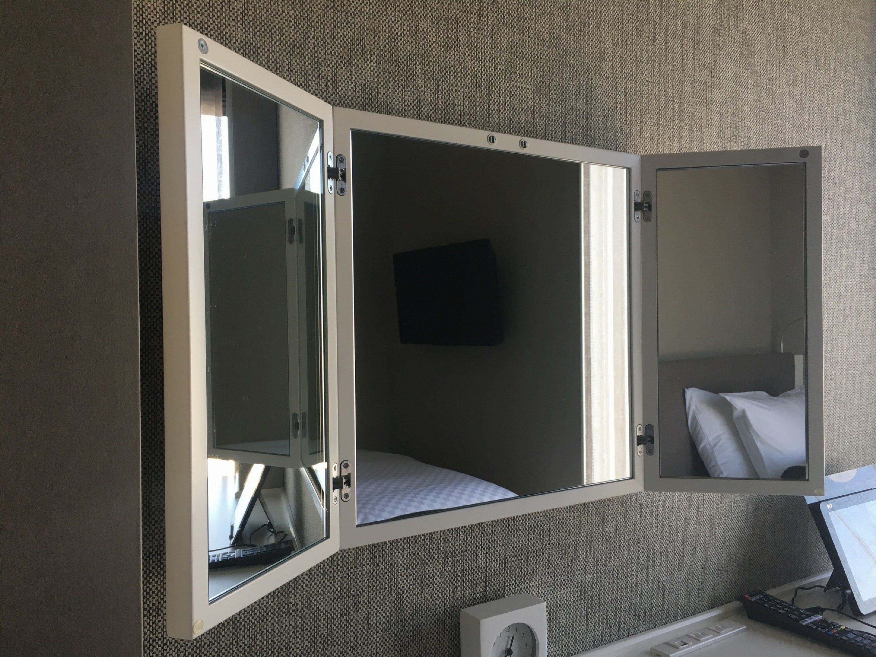 A compact room with a bed, a small desk, and a television.