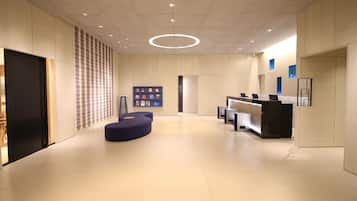A modern reception area with a curved seating area, a reception desk, and a wall-mounted bookcase.