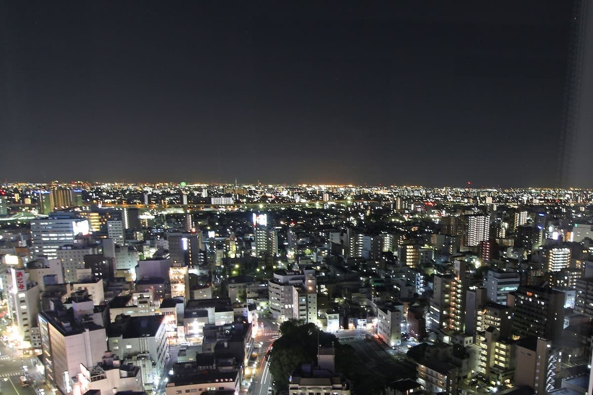 A nighttime cityscape with densely packed buildings and illuminated windows.