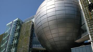 A modern building with a large spherical structure and glass facades.
