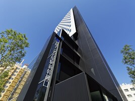 Un edificio moderno con un cartello verticale ben visibile con del testo.