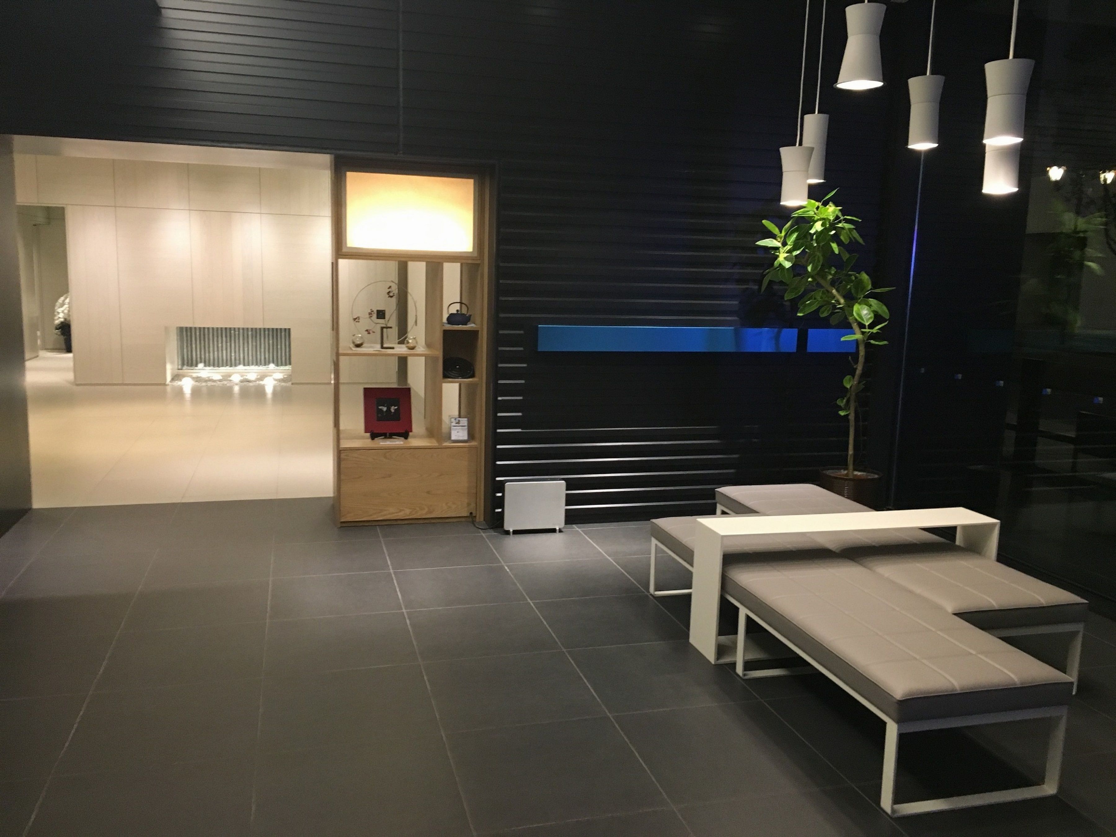 Un interior moderno con mostrador de recepción, zona de estar y una vitrina.